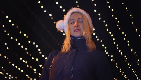 portrait of a woman smiling at the camera and playing in a santa hat