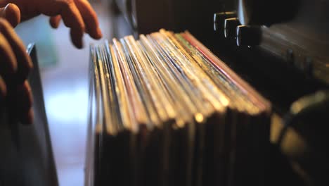 close up man hands browsing vintage vinyl records at home