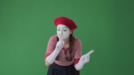 mime artist gesturing with finger on lips