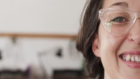 retrato de una feliz trabajadora caucásica con gafas en un estudio de joyas en cámara lenta.