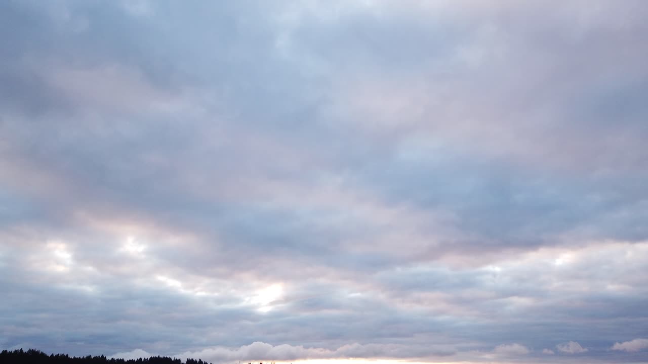Sunrise hyperlapse of streaming clouds over Puget Sound, Tacoma Washington in the background, dolly down pan left and out