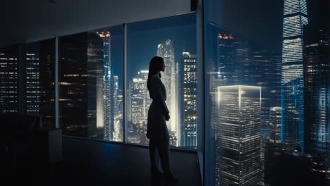 silhouette of a woman admiring the city skyline at night