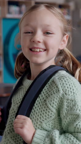 smiling girl with backpack in school