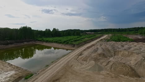 water pond and sand or gravel quarry, aerial fly backward view