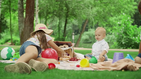 cheerful siblings having picnic in park together. cute children resting outside