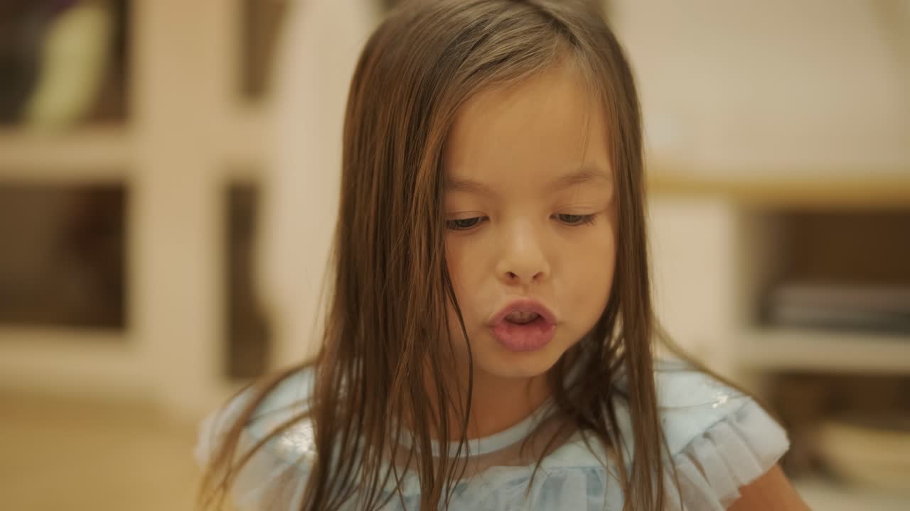 어린 소녀가 집에서 아기 여동생과 즐겁게 놀고 있습니다. 이 순간은 편안한 실내 환경에서 형제자매의 유대감과 가족 사랑을 포착합니다.