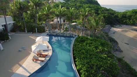 pool with sunbeds in a mexican resort on the beach by the sea