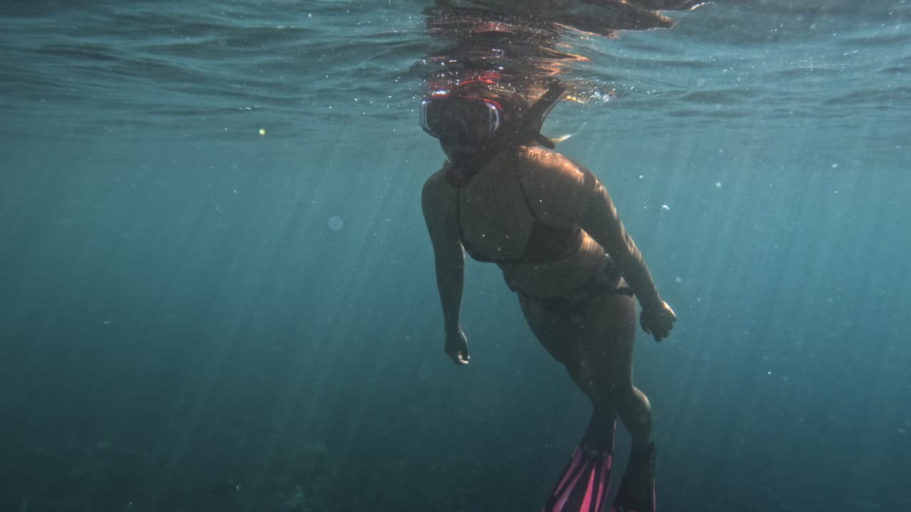 mujer buceando en las aguas claras de tulamben, bali