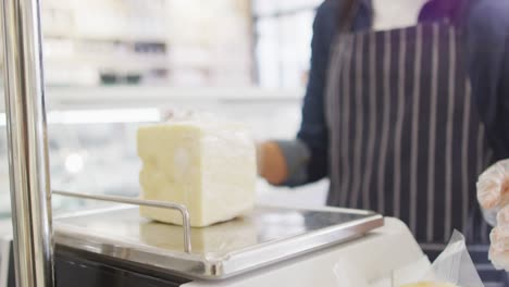 Animation-of-hands-of-biracial-waitress-weighting-cheese