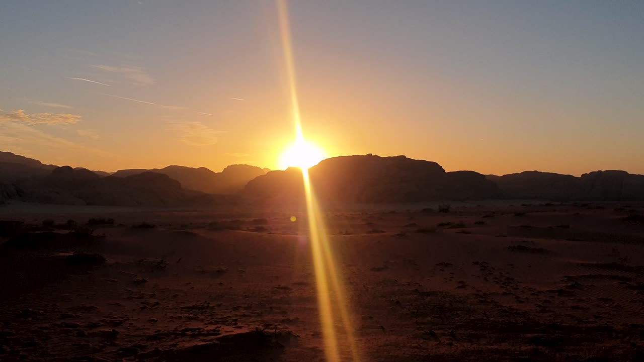 últimos rayos de sol detrás de las montañas con puesta de sol dorada con vistas al vasto paisaje montañoso del desierto árabe en jordania, oriente medio
