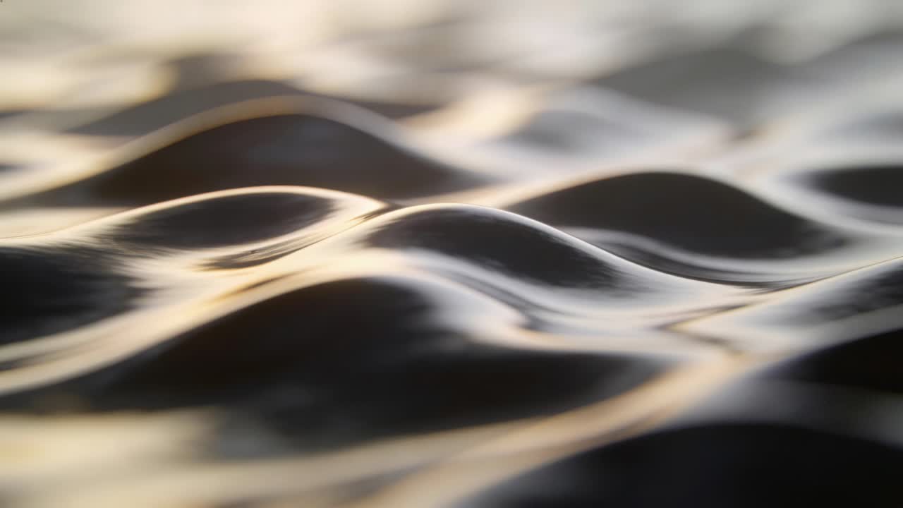 Shifting water surface forming small wavelets and crests as warm sunlight sliding across at sunset