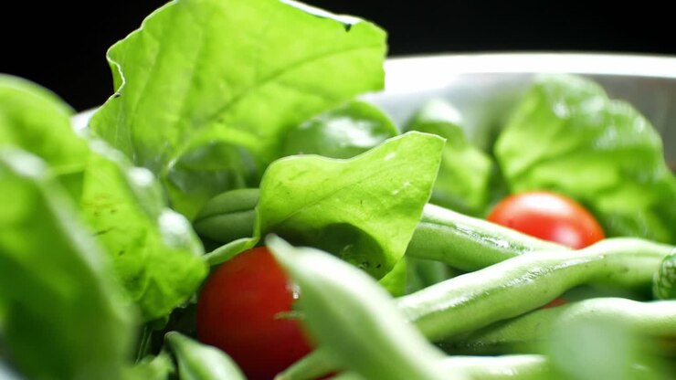 Shallow focus healthy fresh green spinach leaf cucamelon cherry tomato salad bowl closeup slow right dolly