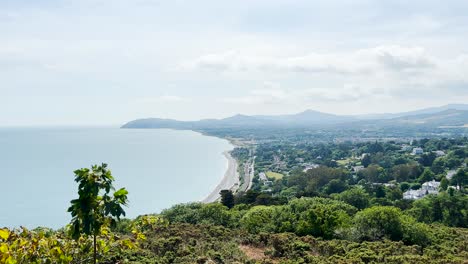 Looking-south-along-Killiney-Beach,-towards-Bray-Head-and-the-Wicklow-Mountains,-Ireland