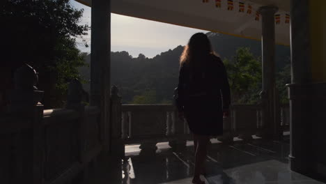 woman walking through a temple balcony in asia