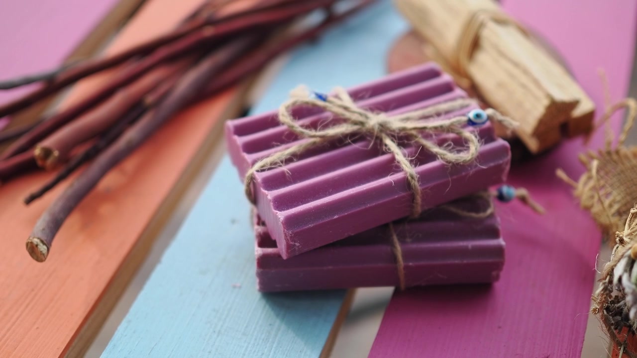 Handmade Purple Soap Bars on Colorful Wooden Surface