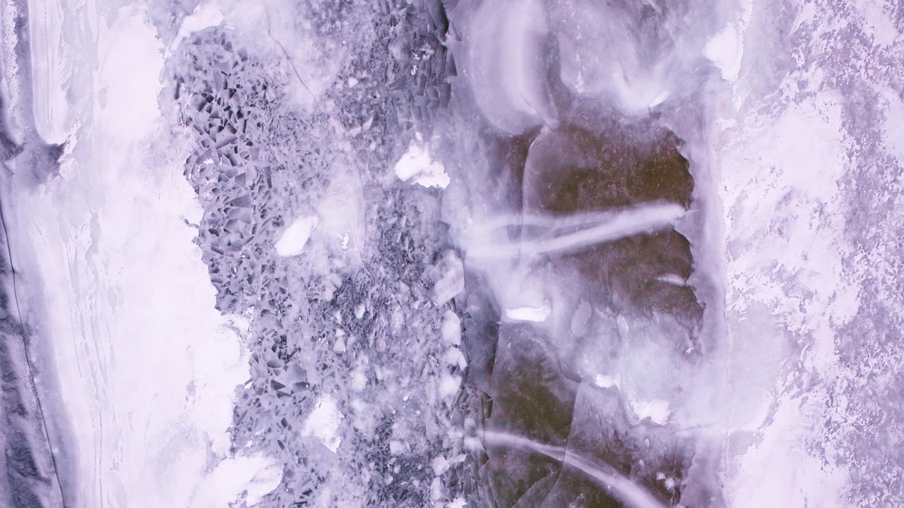 Ripresa aerea dall'alto di formazioni di ghiaccio invernali e texture di lago ghiacciato