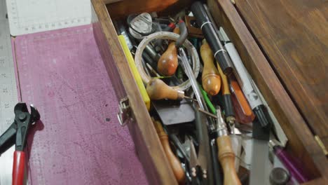 close up of box full of tools in leather workshop