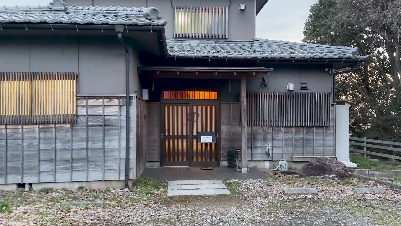Statisk vidvinkelbillede af en traditionel japansk bolig med træskydedøre og tegltag.