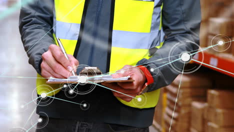 animation of network of connections with icons over caucasian male worker writing in warehouse