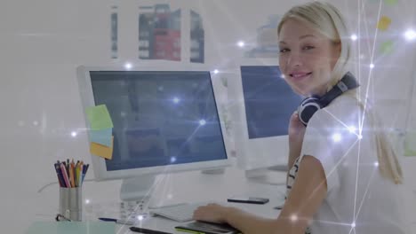 animation of network of connections against caucasian female graphic designer using computer