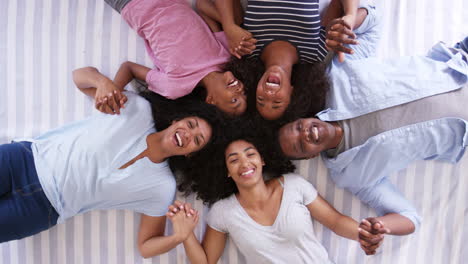 overhead view of family with teenagers lying on bed