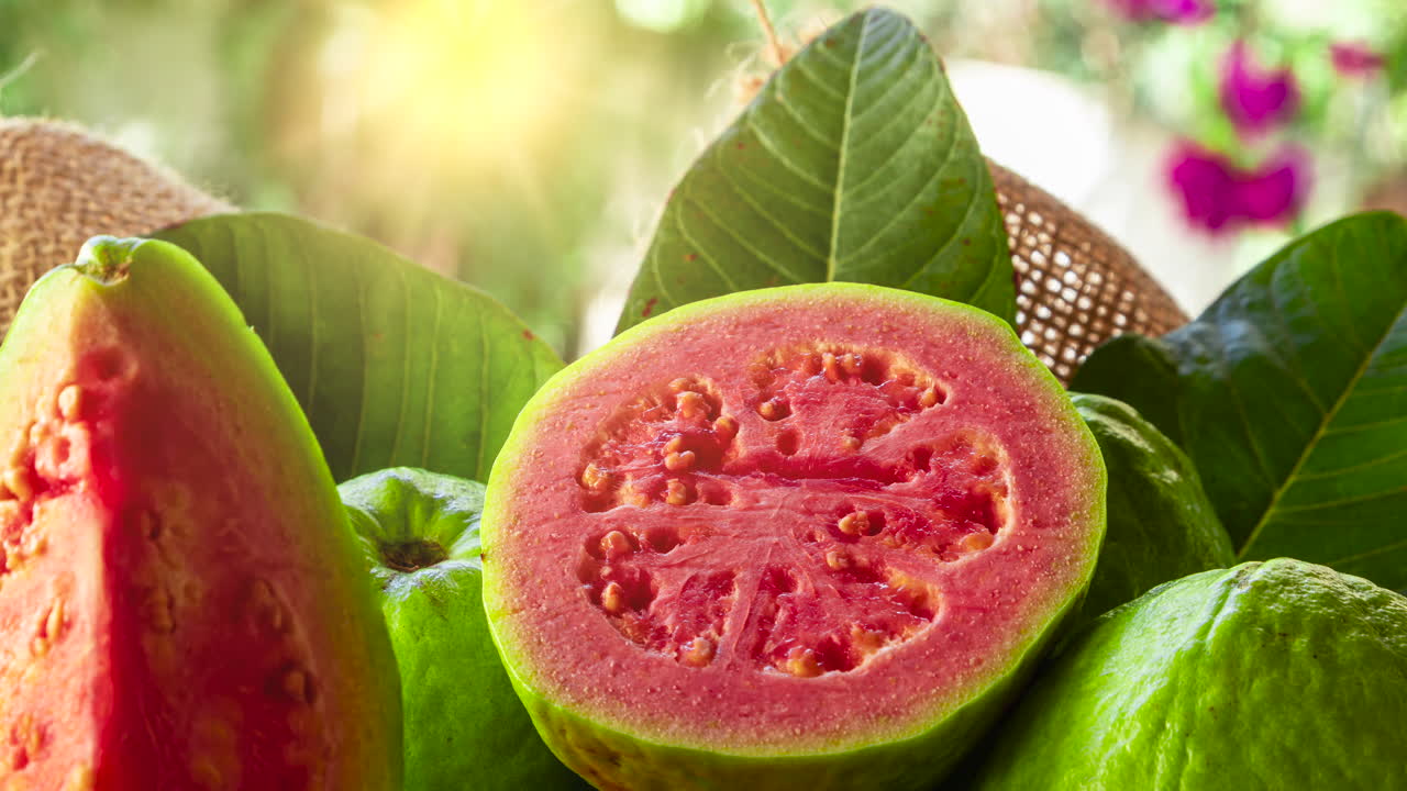 guayabas rojas cortadas y puesta de sol al fondo