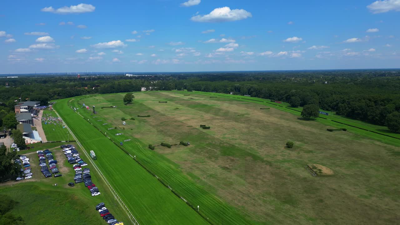 horse racing track with spectators enjoying the competition on a sunny summer day. Amazing aerial view flight descending drone