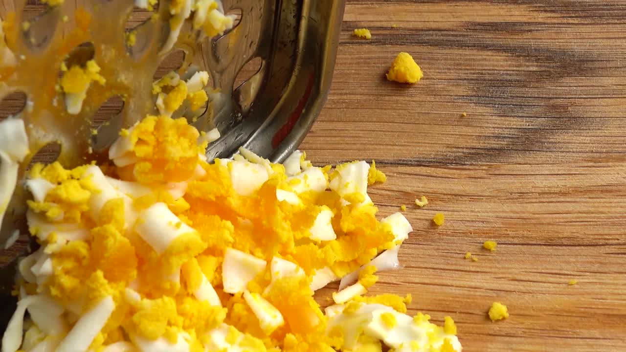 Le cuisinier râpe un œuf. Travail du cuisinier