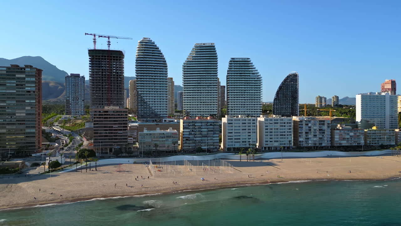 Aerial drone view of the buildings along the coastline and the sea in Benidorm, Spain in daylight
