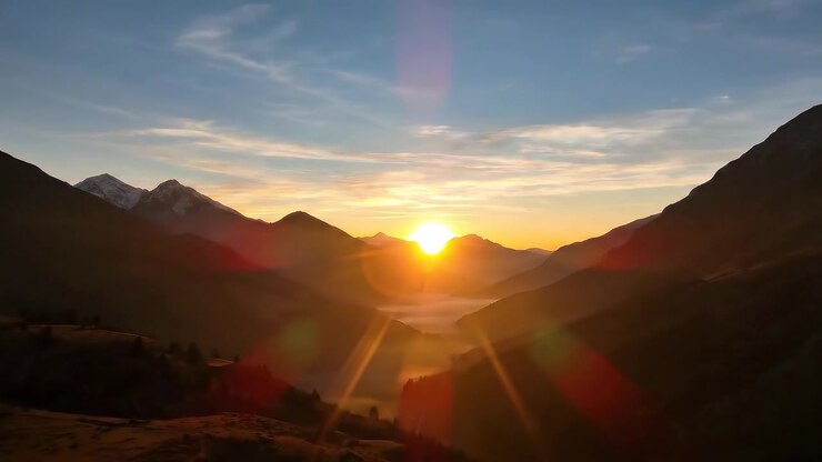 Amanecer sobre un valle montañoso con niebla matutina