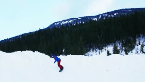 Person-snowboarding-on-snowy-mountain