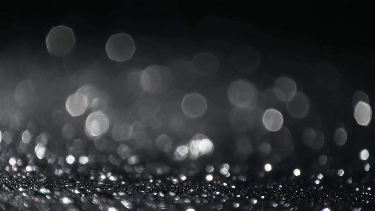 Abstract Silver Glitter Particles Shimmering on Dark Background