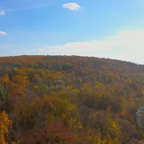 flight over autumn forests, meadows and hills in sunrise. slow flight over autumn forest and great river in the morning. shooting from a bird's eye view