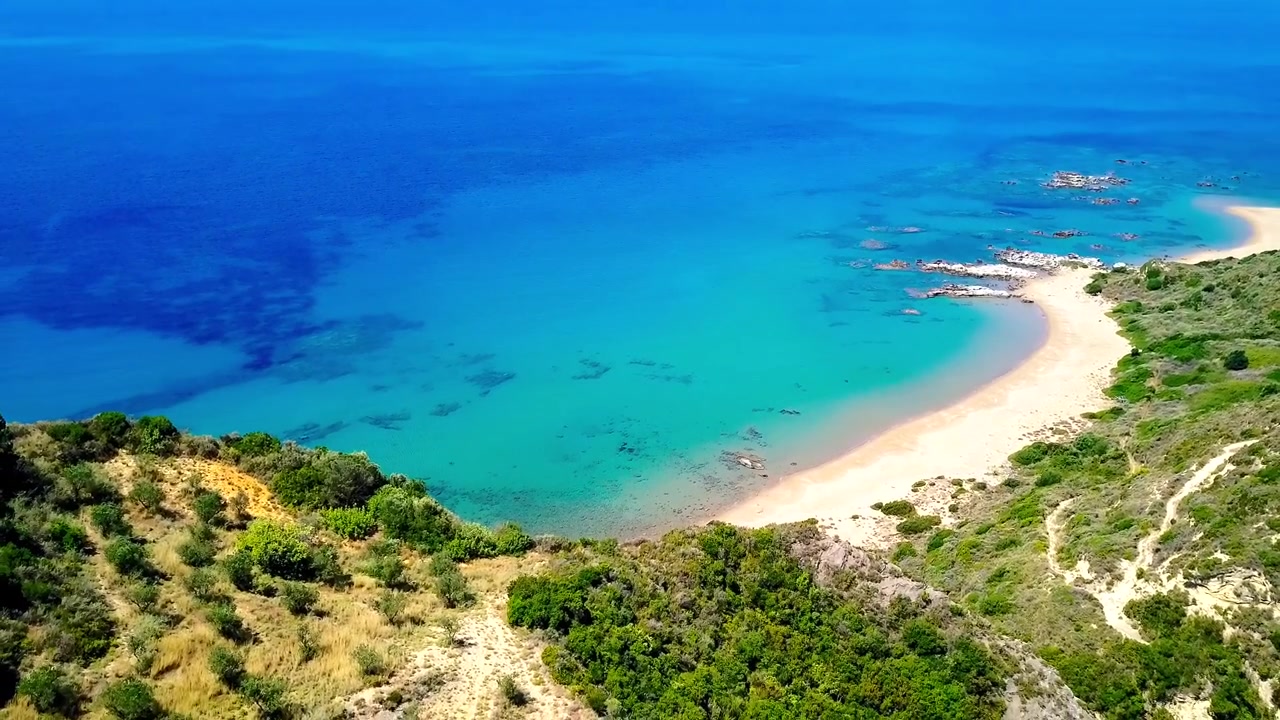 Splendide riprese aeree della spiaggia sabbiosa e curva della Penisola di Hel, con le acque turchesi del Baltico, dune verdi lussureggianti e bassi fondali rocciosi. Catturate sotto la brillante luce solare estiva con chiarezza cinematografica.