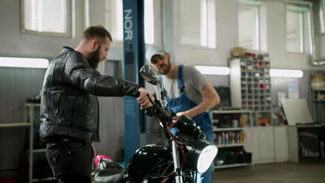 Mechanic-and-rider-talking-at-the-garage