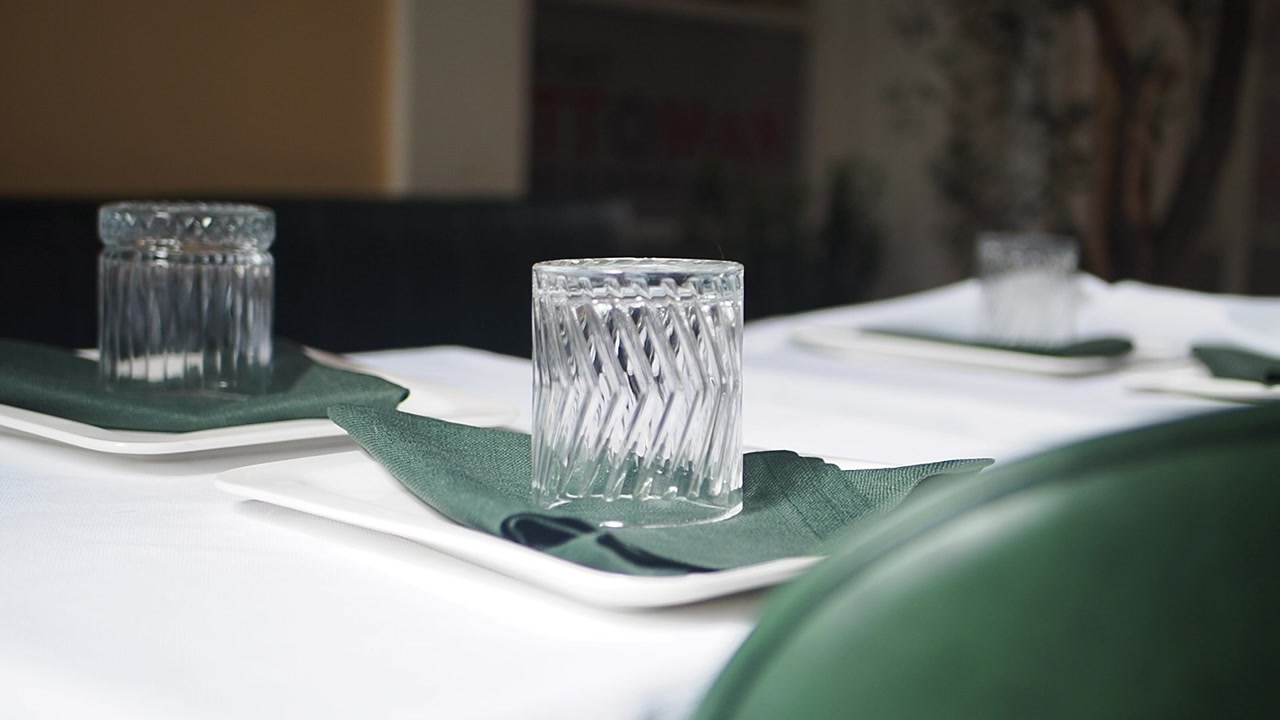 Elegant Table Setting with White Plates and Green Napkins in a Restaurant