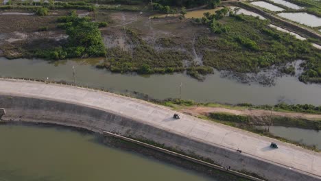 Bholaganj-flood-embankment-road-with-vehicles-driving-by,-aerial-view,-dolly-in