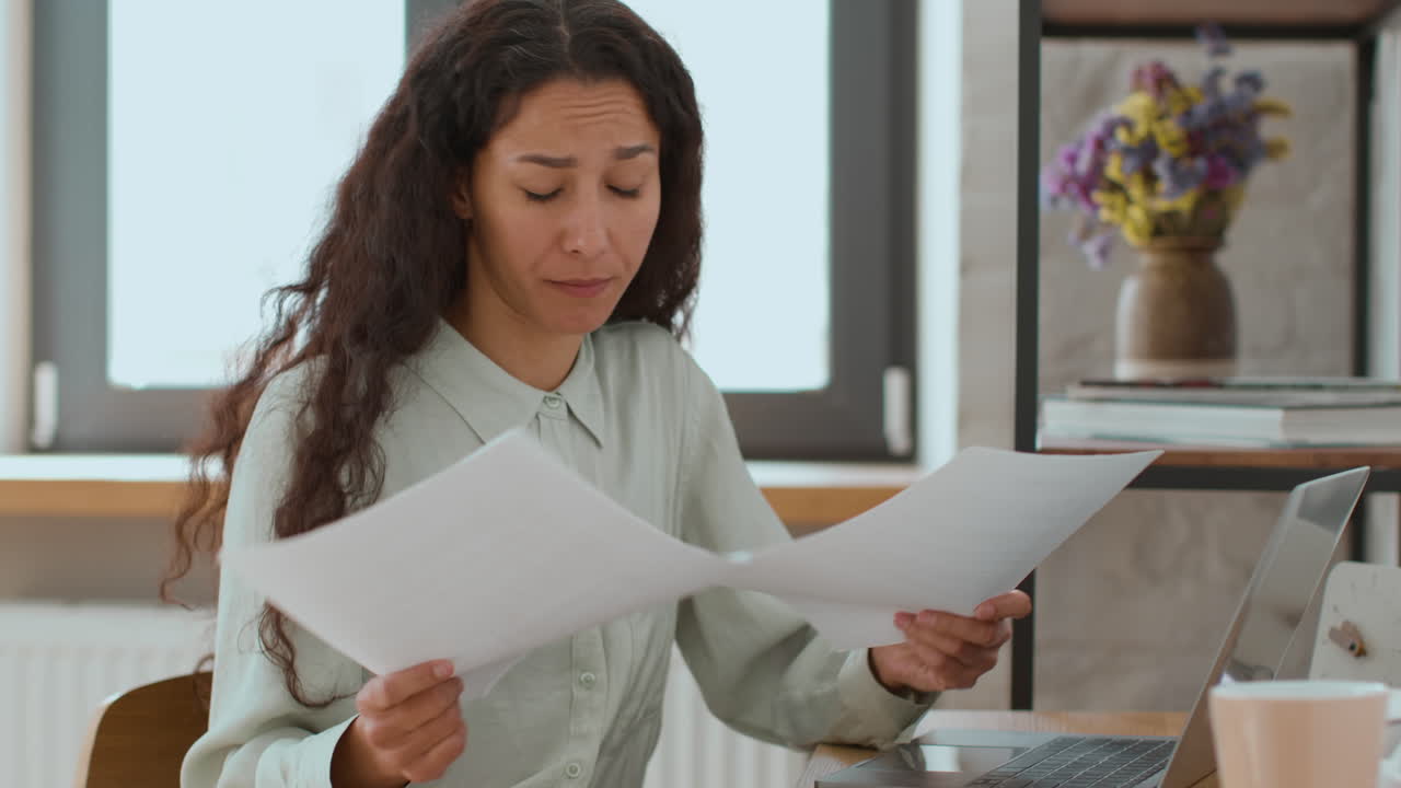 Woman reviewing documents on a laptop