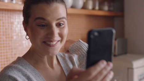 Mujer-Feliz-Teniendo-Video-Chat-Usando-Un-Teléfono-Inteligente-En-Casa-Charlando-Con-Un-Amigo-Disfrutando-De-Una-Conversación-Compartiendo-Su-Estilo-De-Vida-En-Un-Teléfono-Móvil