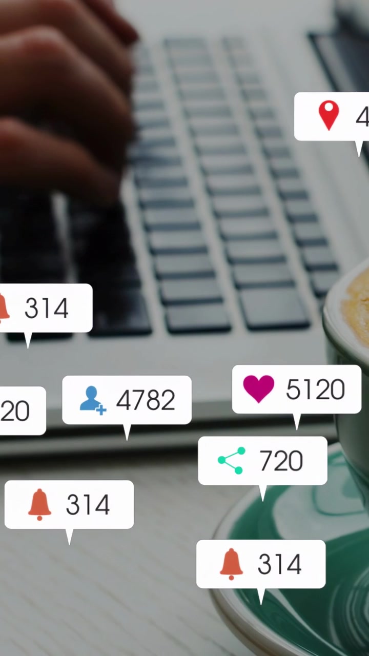 Vertical video: Hands typing for marketing, causing icons and counts popping over keys and cup