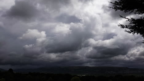 relámpagos en nubes oscuras de tormenta sobre árboles y valles