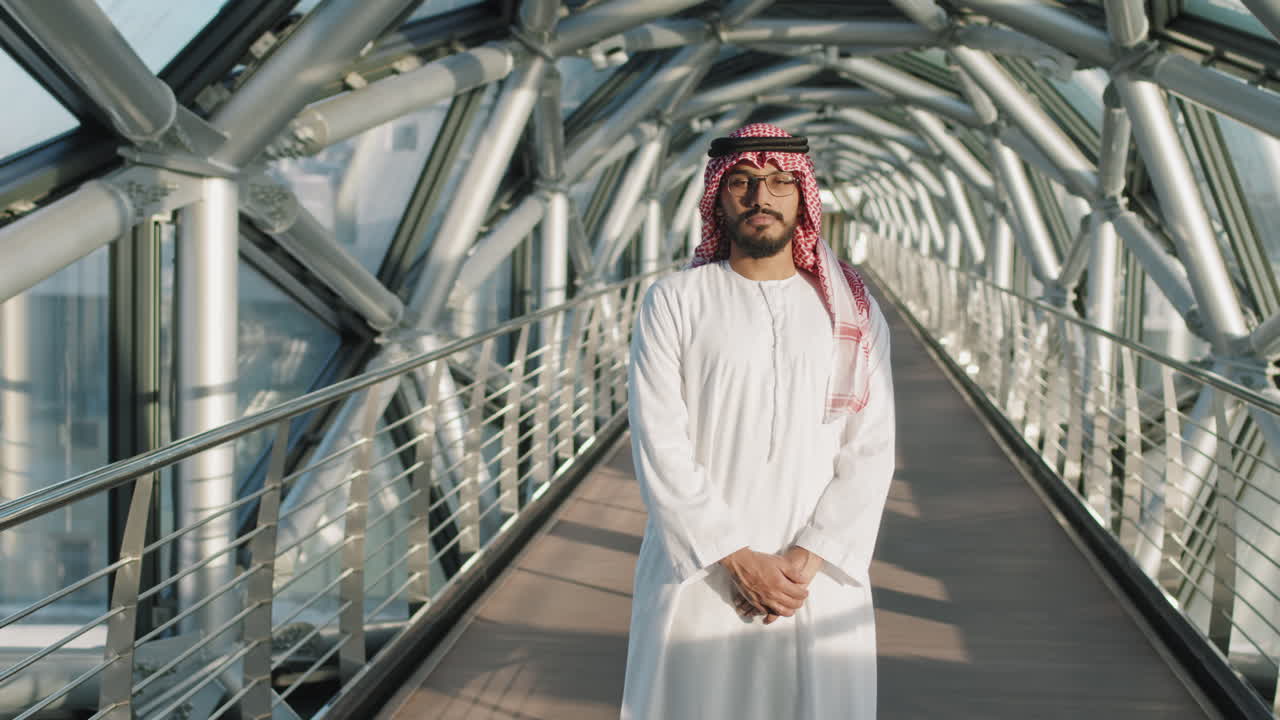 hombre de oriente medio de pie en el puente de vidrio