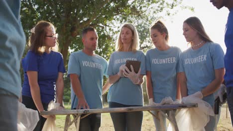 adultos de mediana edad como voluntarios y mujeres tomando notas durante el día de limpieza del río