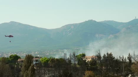 Helicóptero-Bombero-Acercándose-A-Un-Incendio-Forestal-En-La-Montaña-Parnitha,-Grecia