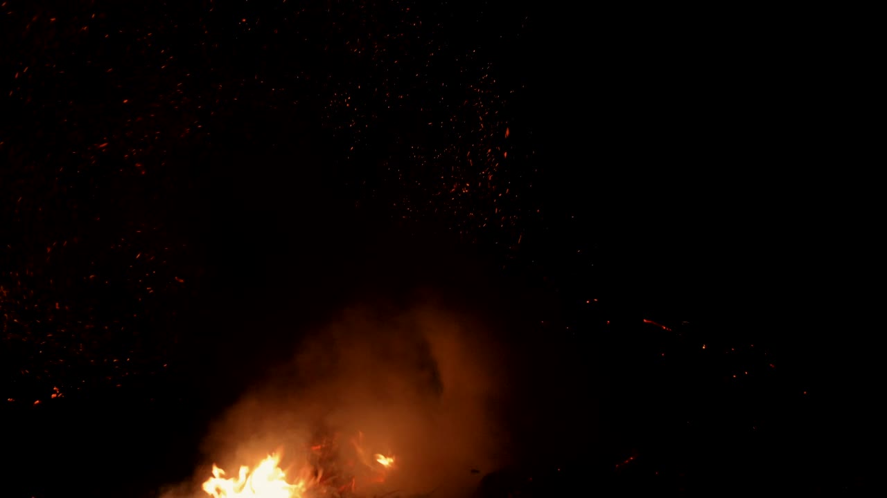alimentando una hoguera ardiente con brasas mágicas voladoras en el cielo nocturno invernal