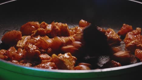 persona revolver en una sartén llena de carne de pollo cocinando la cena