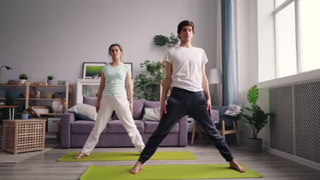pareja practicando yoga en casa