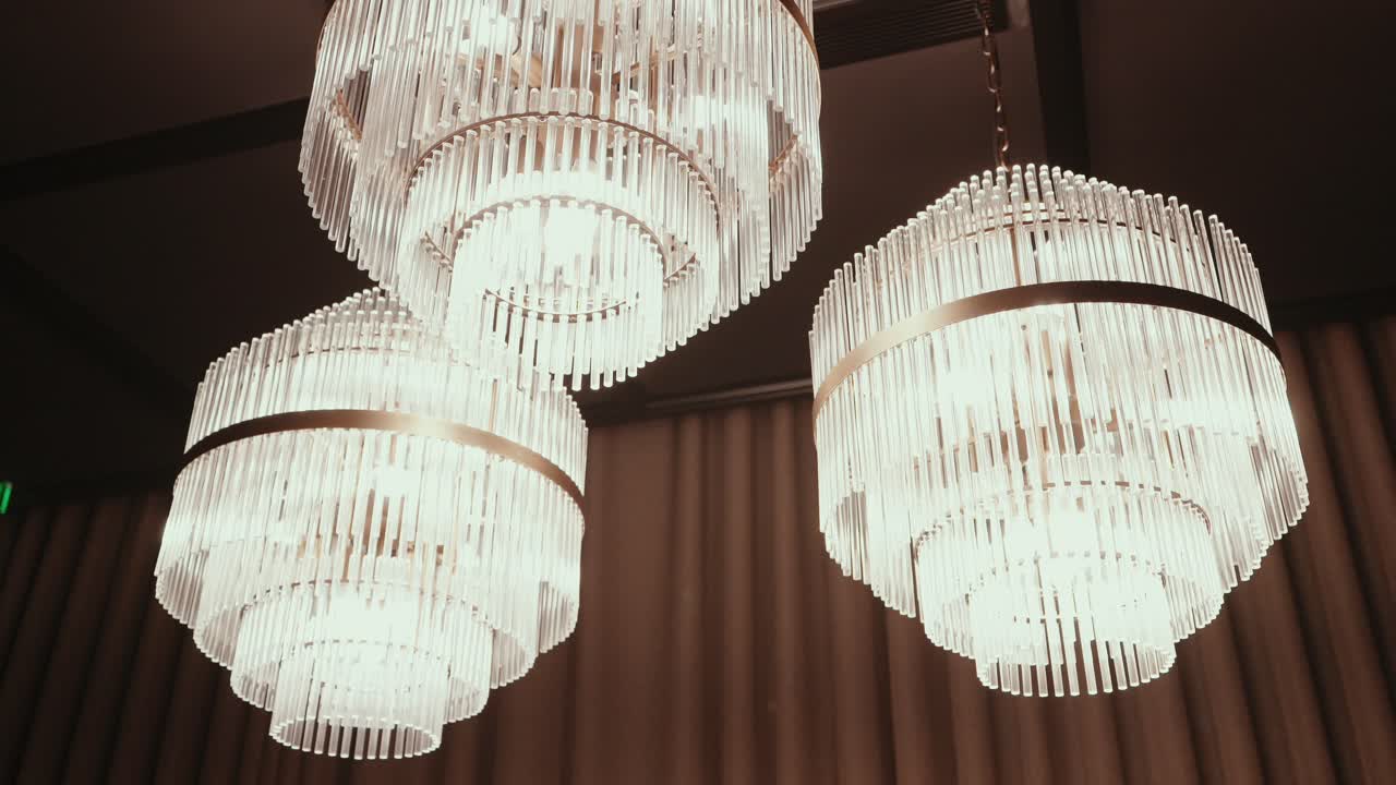 glowing crystal chandeliers add elegance to upscale indoor setting