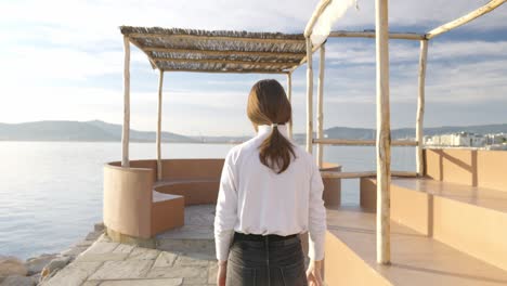 Dolly-in-shot-while-following-a-woman-that-walks-on-a-pier