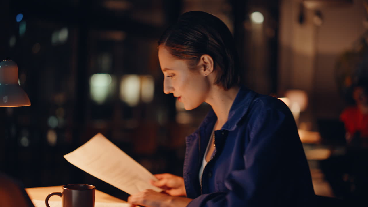 Successful investor working evening office reviewing papers closeup smiling